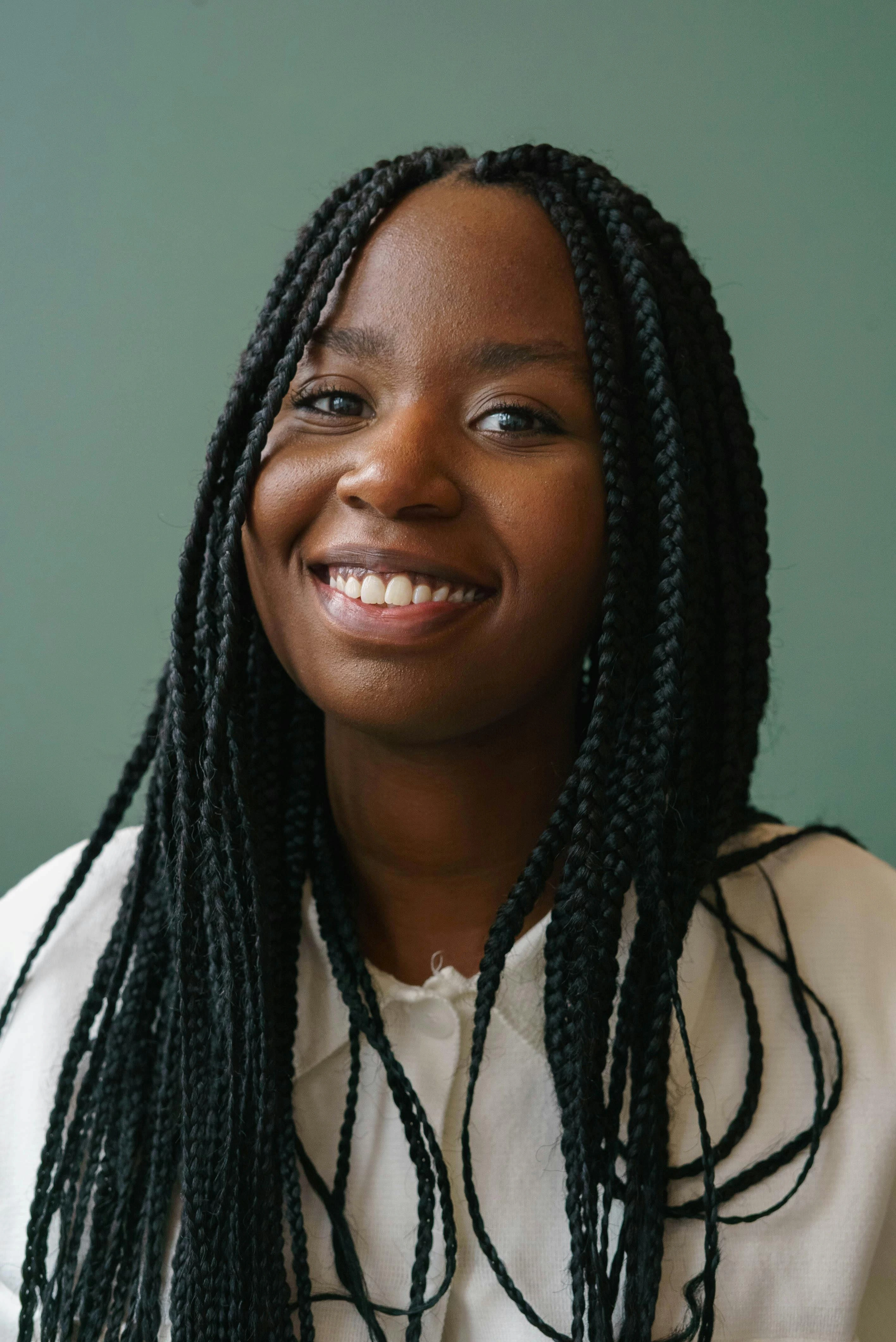 Photograph of a professional woman in a suit and glasses in an office setting.